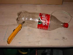 Cut the bottom off the second bottle to create a dust lid.